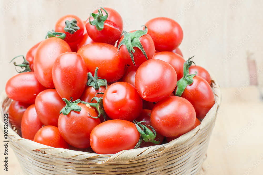 Tomato in basket on wood background Tomato in basket on wood background
