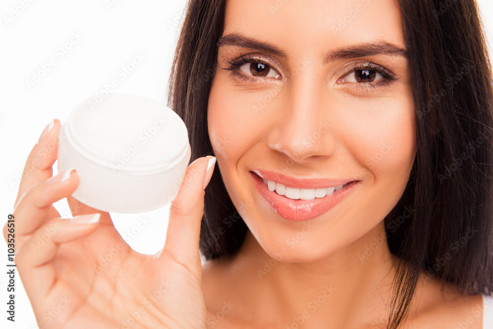 Close up photo of young pretty brunette holding jar of cream Close up photo of young pretty brunette holding jar of cream