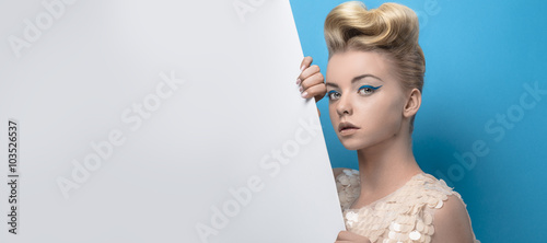 Beautiful young blonde woman holding a white board