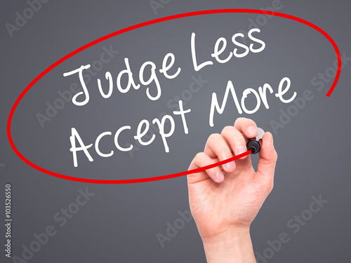 Man Hand writing Judge Less Accept More with black marker on vis