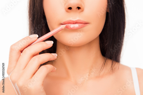 Young woman doing maquillage with lip s liner  close up photo