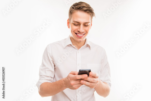Young cheerful businessman typing sms on his smartphone © deagreez
