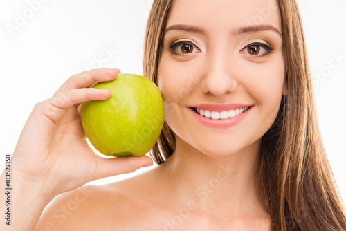Cute beautiful girl showing her white smile with green apple