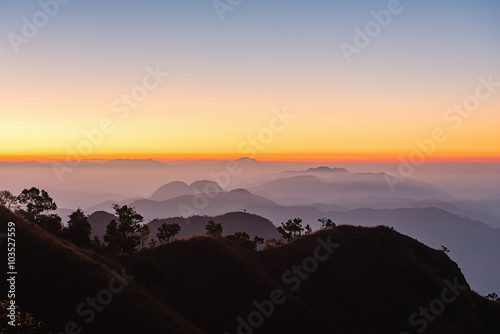 Sunset over black mountains in the fog  Mountain layer background