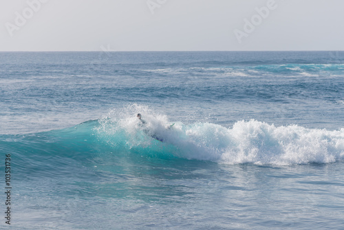 Bodyboarding and surfing in the waves of the Atlantic in front of the island La Gomera. A short light type of surfboard ridden in a prone position