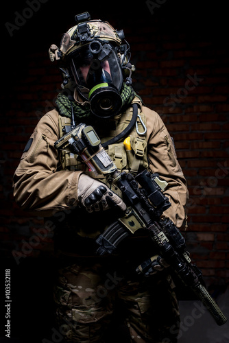 Soldier in gas mask with rifle in hands/Soldier in uniform and respirator standing on dark background with  rifle