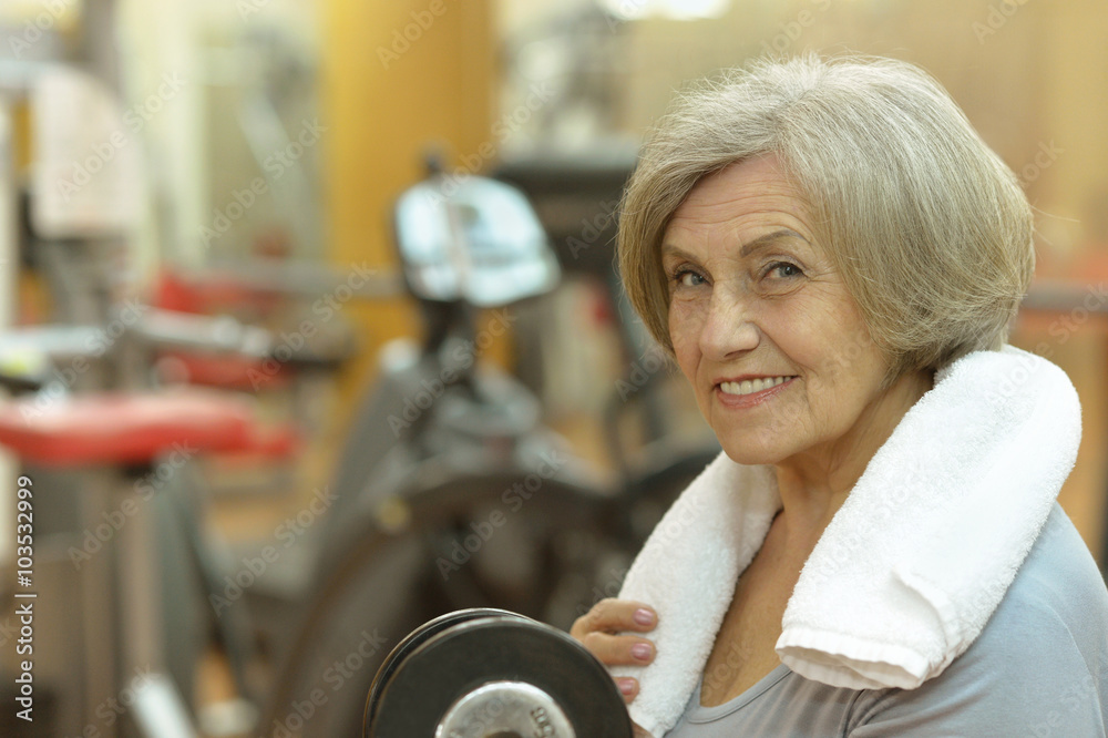 Obraz premium Elderly woman exercising in gym
