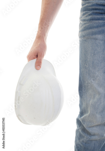 Male engineer in jeans holding white hardhat