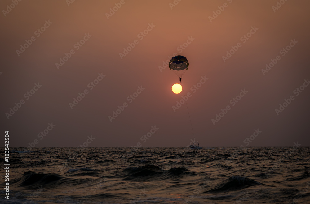 Fototapeta premium A couple parasailing during sunset in the Indian city of Goa