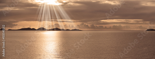 Caribbean island sunset with suns rays panorama photo