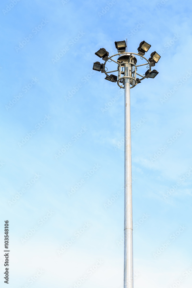 Spot-light tower at the road on blue sky