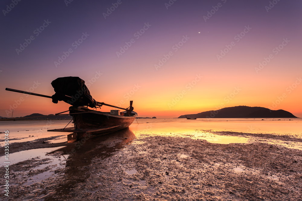 Traditional Thai longtail boat at sunrise beach in Phuket