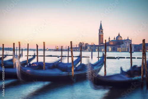 Venetian gondolas and San Giorgio di Maggiore church in background at morning before sunrise, long time exposure, vintage filtered style, Venice (Venezia), Italy, Europe   © AR Pictures
