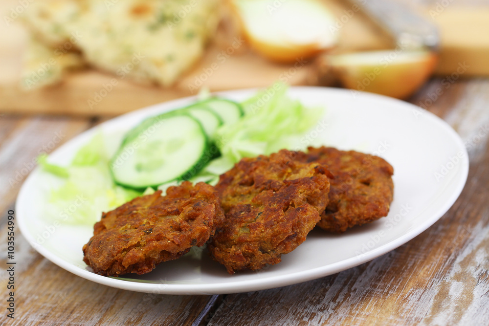 Onion bhajis with side salad on white plate, closeup
Onion bhajis with side salad on white plate, closeup