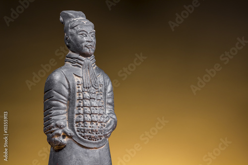 Ancient chinese warrior on rising sun background. Terracotta figurine.