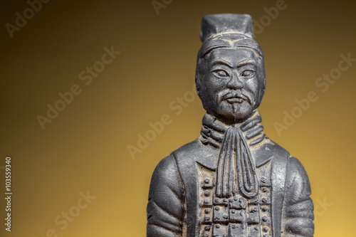 Terracotta figurine of ancient chinese warrior on rising sun background. Clear space at left.