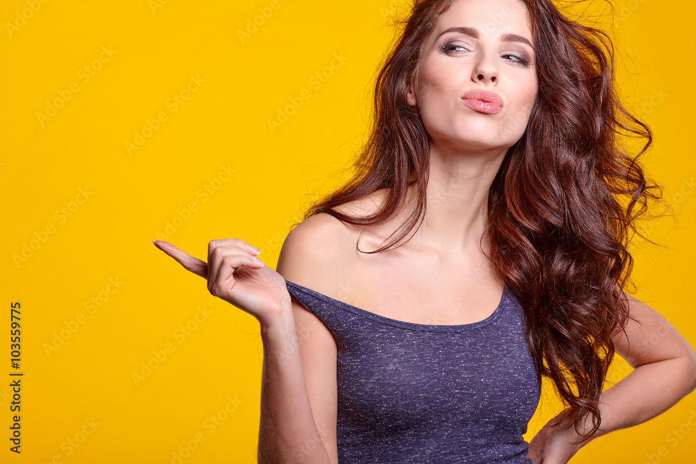 Beautiful summer girl smiling at camera, over yellow background.