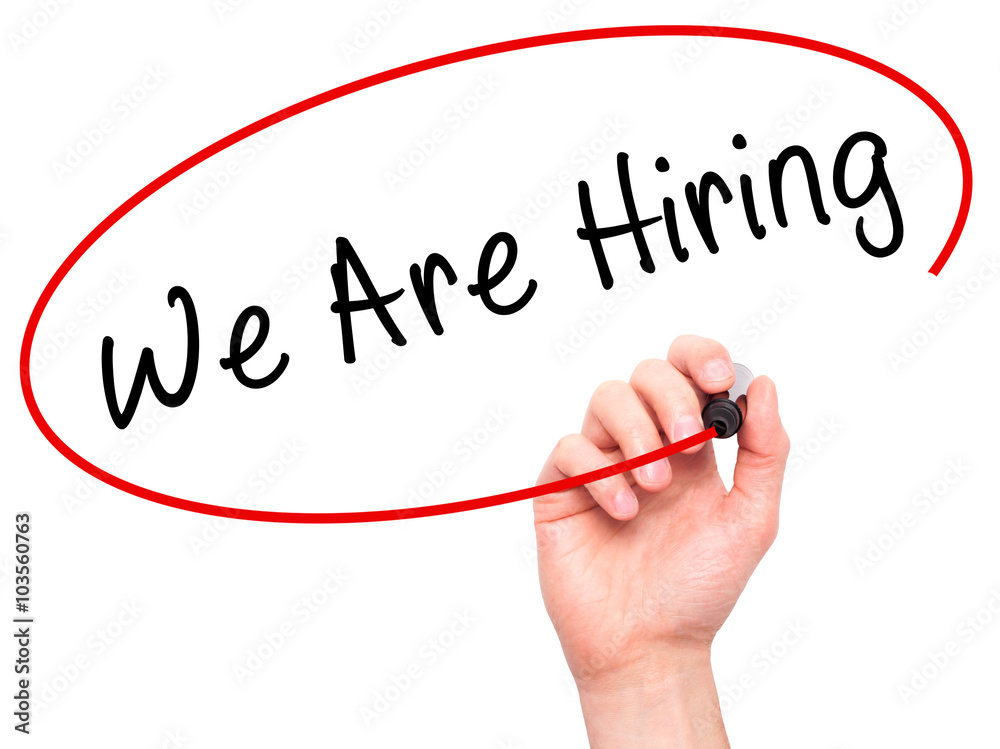 Man Hand writing We Are Hiring with black marker on visual scre Man Hand writing We Are Hiring with black marker on visual scre
