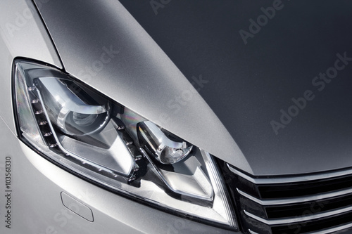 close up headlight of grey car at daytime
