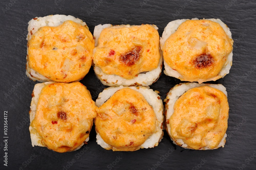 Set of yummy baked hot cheese rolls on black plate