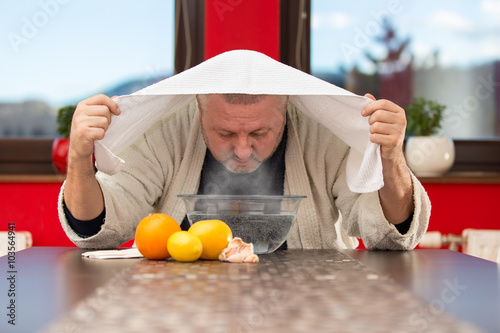 Mature man with colds and flu. Inhalation of herbs
