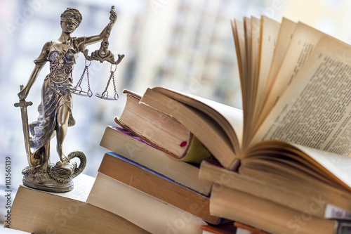 Justice statue with sword and scale and books. Law concept