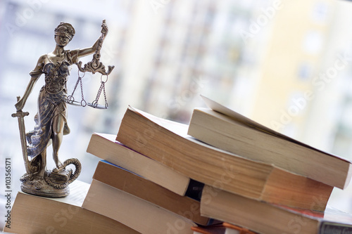 Justice statue with sword and scale and books. Law concept