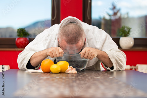 Mature man with colds and flu. Inhalation of herbs