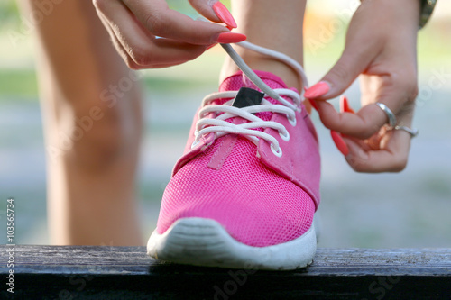 Runner girl tying pink shoes
