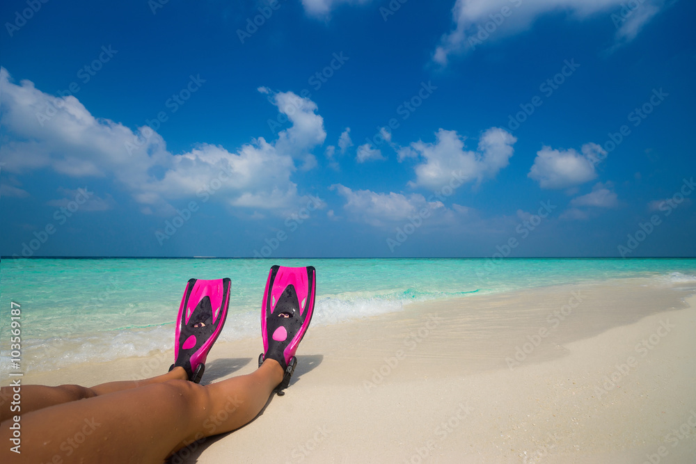 Woman relaxing on summer beach vacation holidays lying in sand.