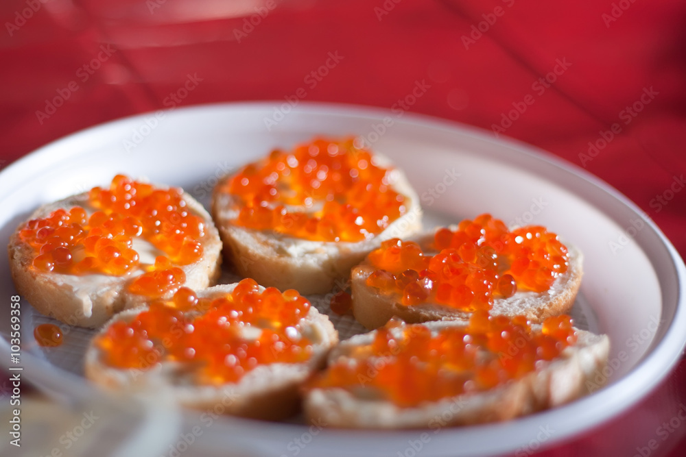 Red caviar on white plate close-up