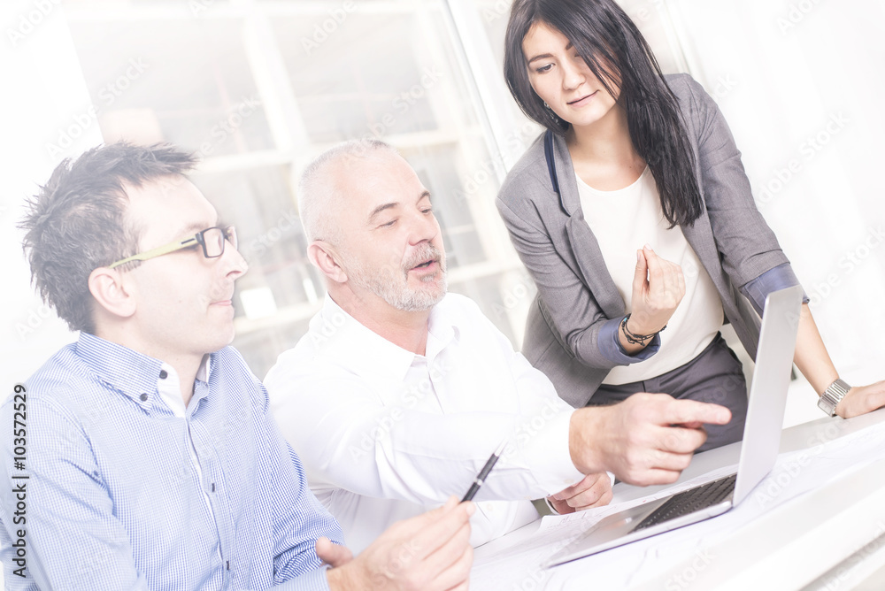 Successful business people interacting, discussing and sharing ideas in bright modern office. Teamwork concept. Focus on man in the middle, Lens flare effect Successful business people interacting, discussing and sharing ideas in bright modern office. Teamwork concept. Focus on man in the middle, Lens flare effect