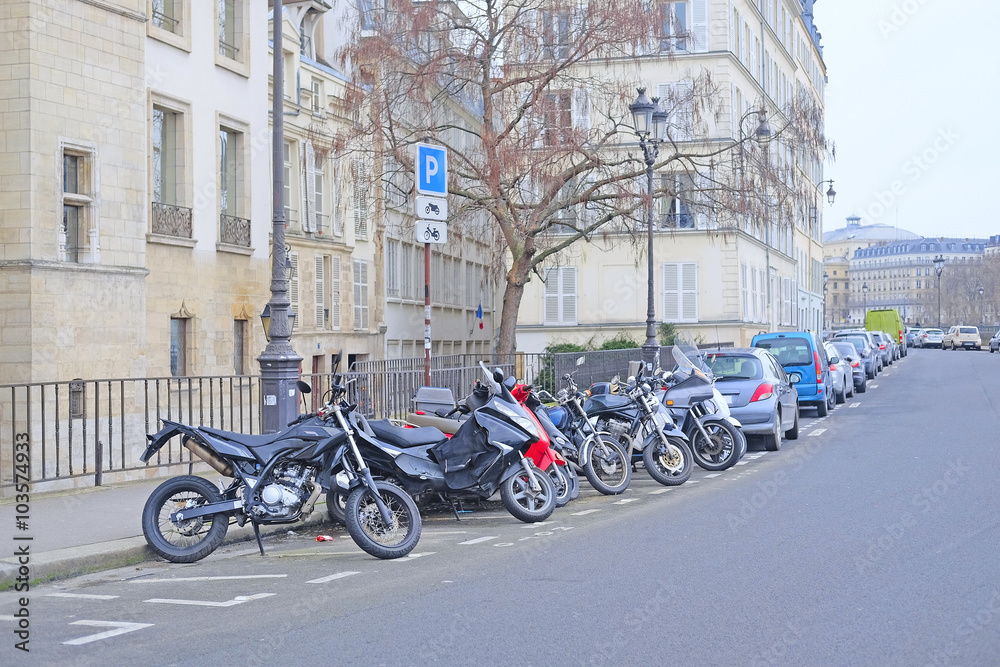 Fototapeta premium Paris, France, February 9, 2016: motorcycle parking on a street in a center of Paris, France. Motorcycles are very popular transport in Paris
