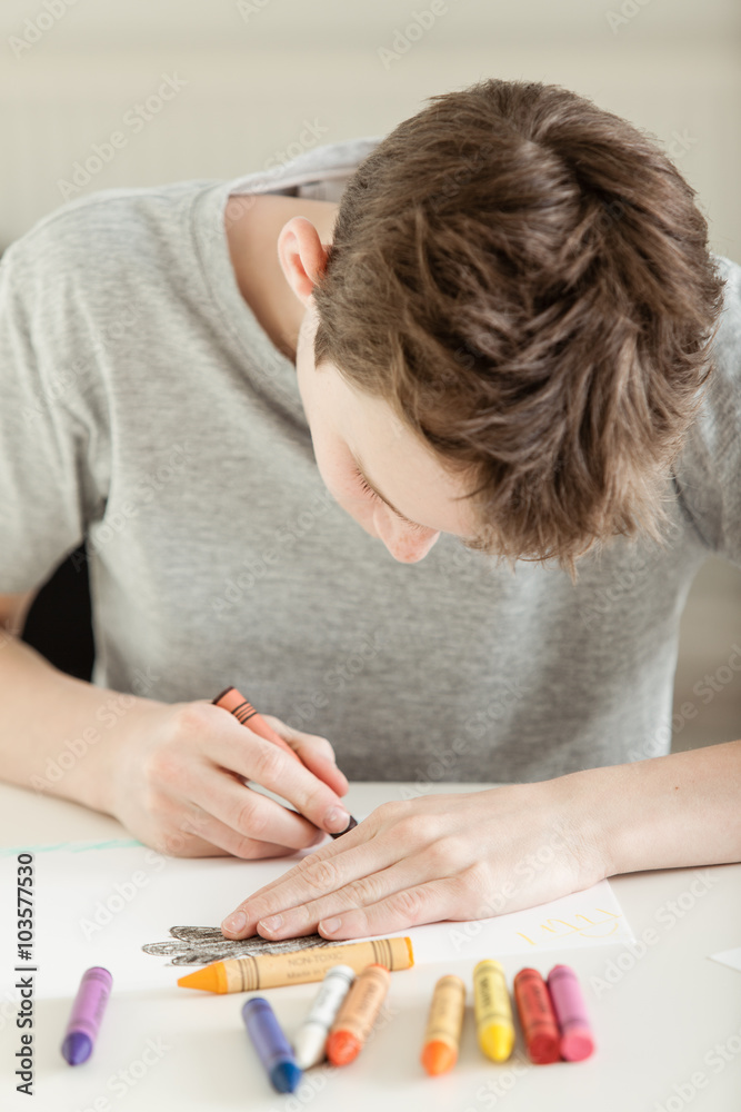 Young Boy Drawing on White Paper with Crayons