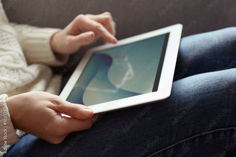 Female hand holding PC tablet on home interior background Female hand holding PC tablet on home interior background
