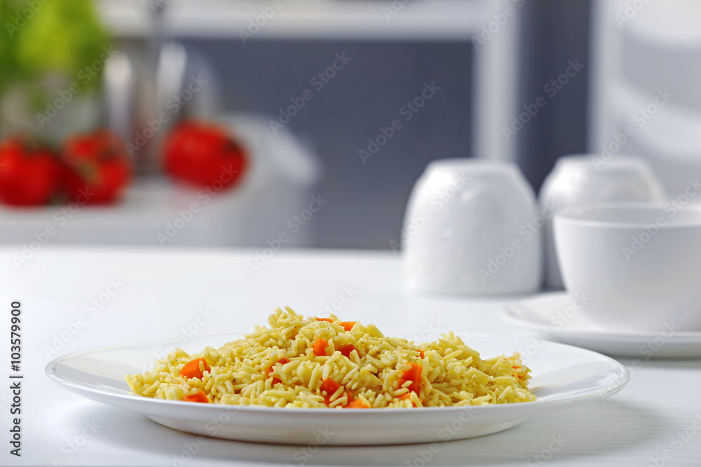 Stewed rice with a carrot on a white plate Stewed rice with a carrot on a white plate