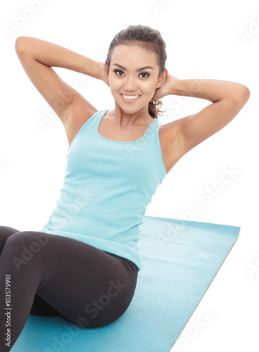 sporty young women lying on the floor while doing sit ups