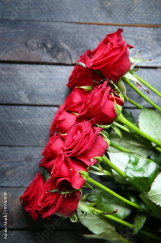 Bouquet of fresh red roses on wooden background