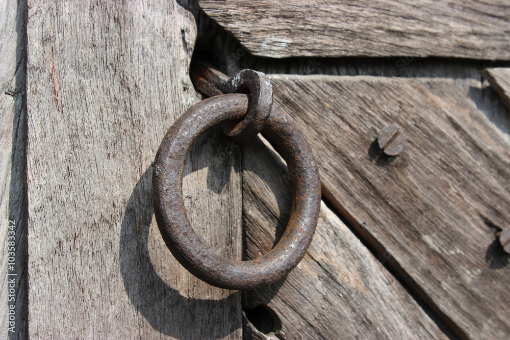 Rusty screw in old wooden door with iron handle. Rusty screw in old wooden door with iron handle.