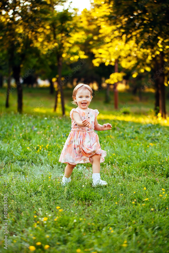 Happy cute little girl running on the grass in the park. Happine Happy cute little girl running on the grass in the park. Happine