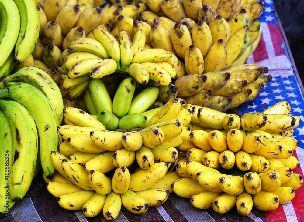 Hands of fresh yellow bananas at a market in Laos