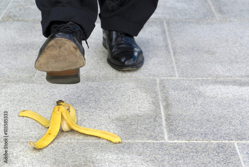 Фотография Man or businessman stepping slipping on banana skin peel danger accident photo