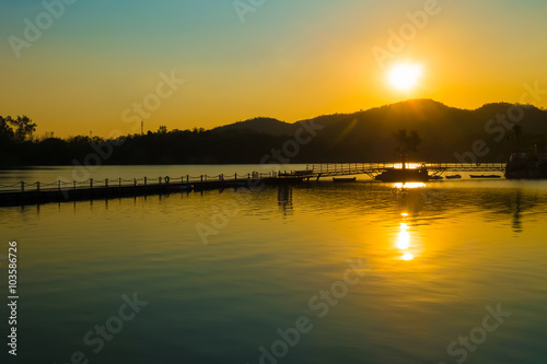 The sunset over the lake and the mountains in Thailand.