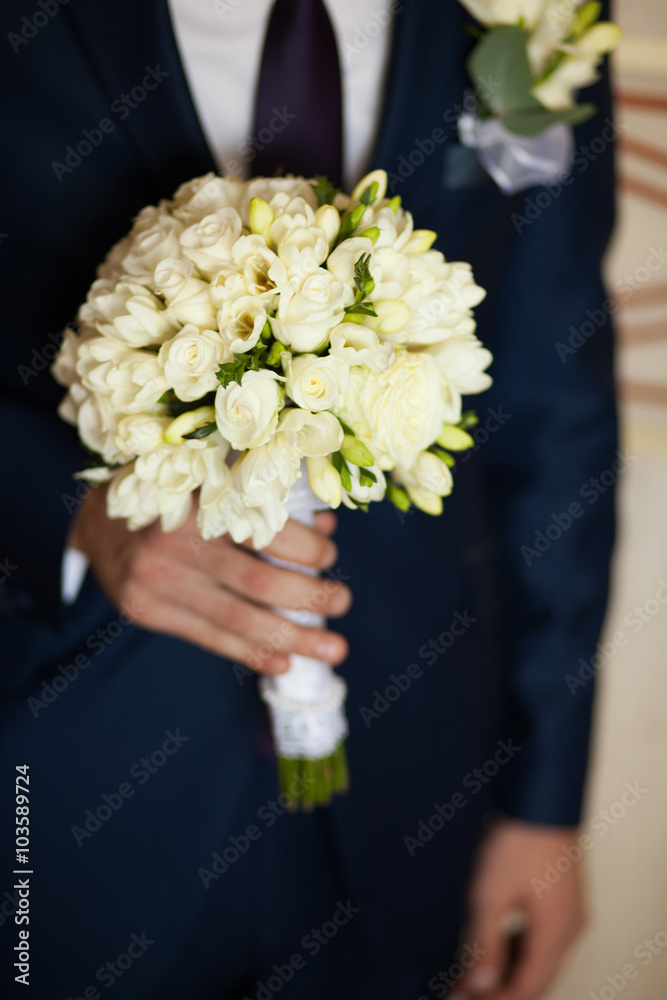 Groom holding the bouquet of flowers Groom holding the bouquet of flowers