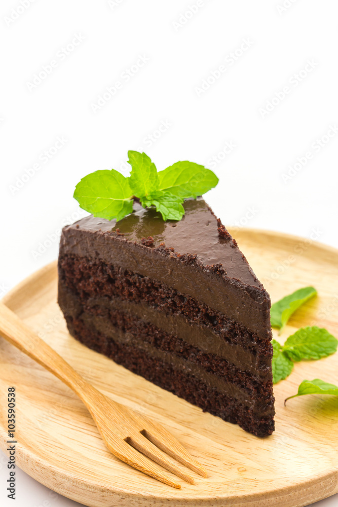 Chocolate cake slice in wooden plate.