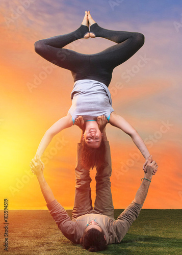 The two people doing yoga exercises 