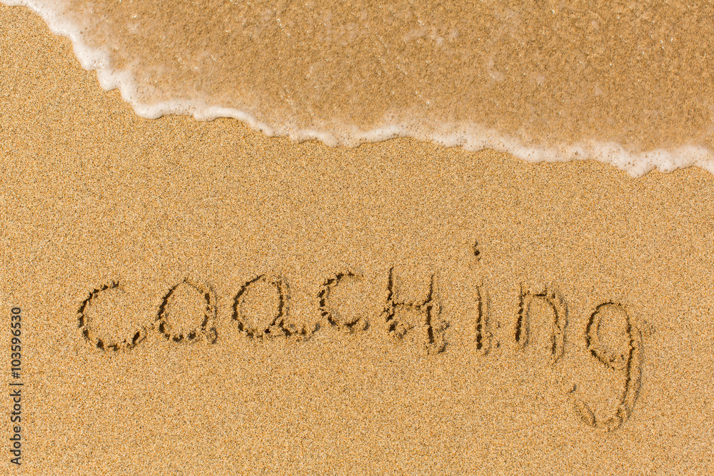 Fototapeta premium Coaching - written on sandy beach with the soft wave.