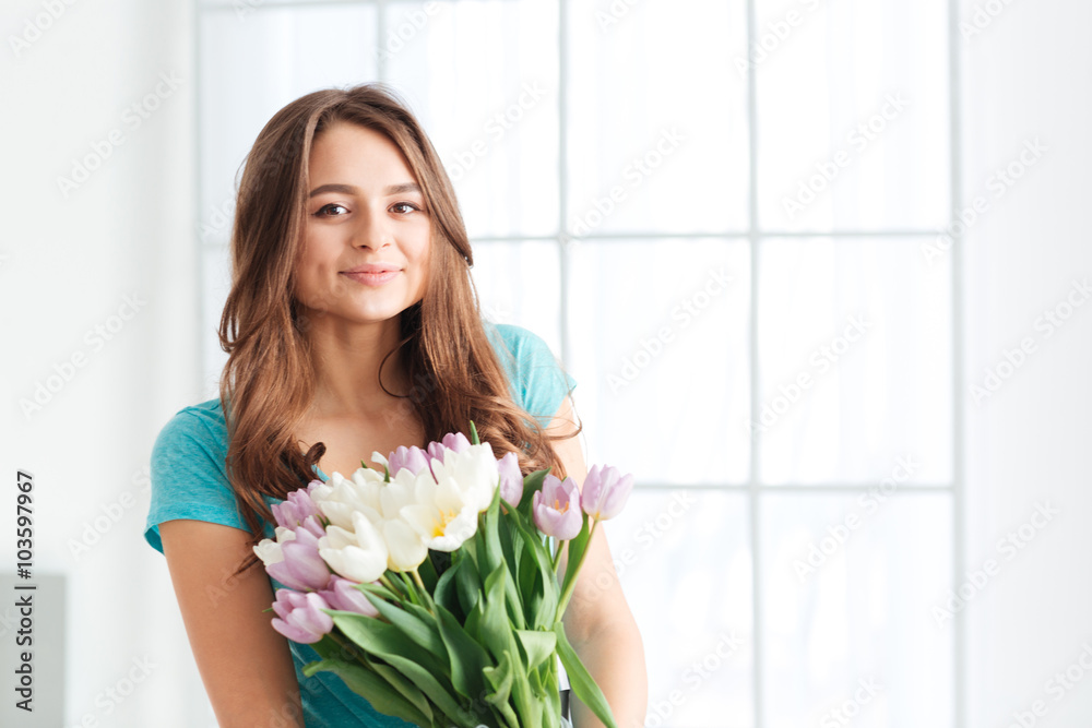 Happy beautiful young woman holding bouquet of tulips Happy beautiful young woman holding bouquet of tulips