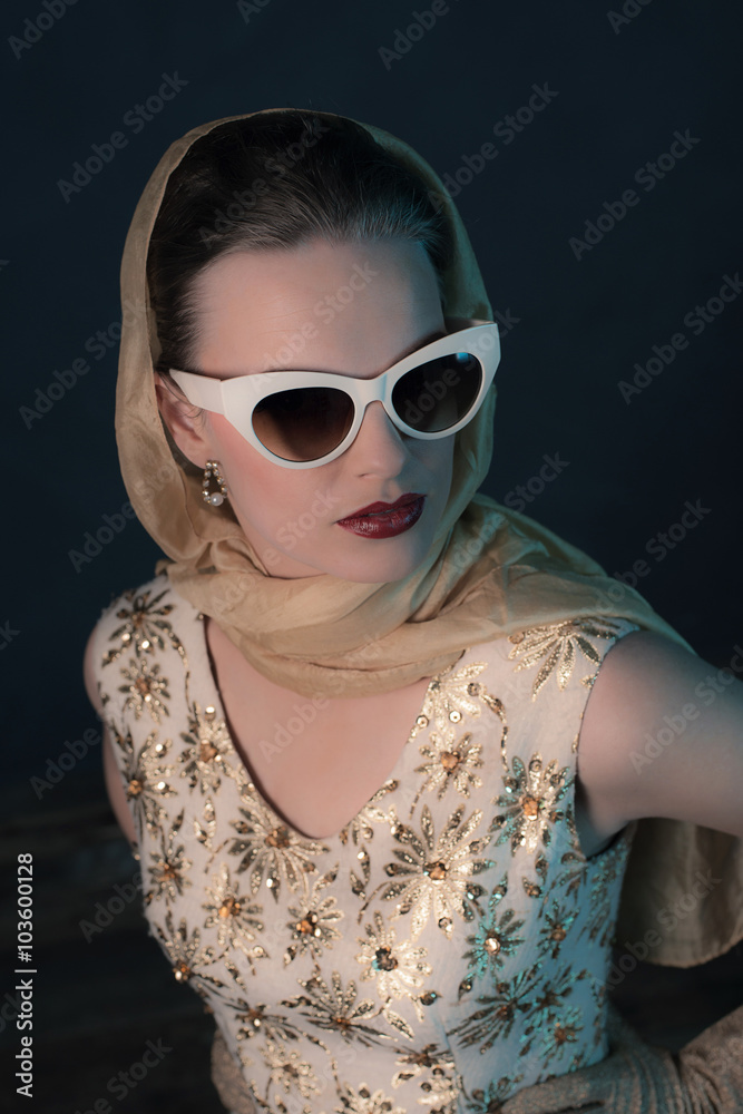 Chique vintage 50s fashion woman wearing sunglasses and scarf ar