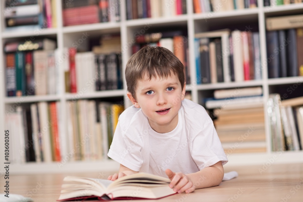 Happy little boy reading a book at home. Happy little boy reading a book at home.